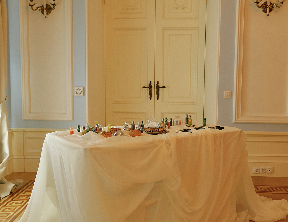 Стол с полупрозрачными тканями и угощениями